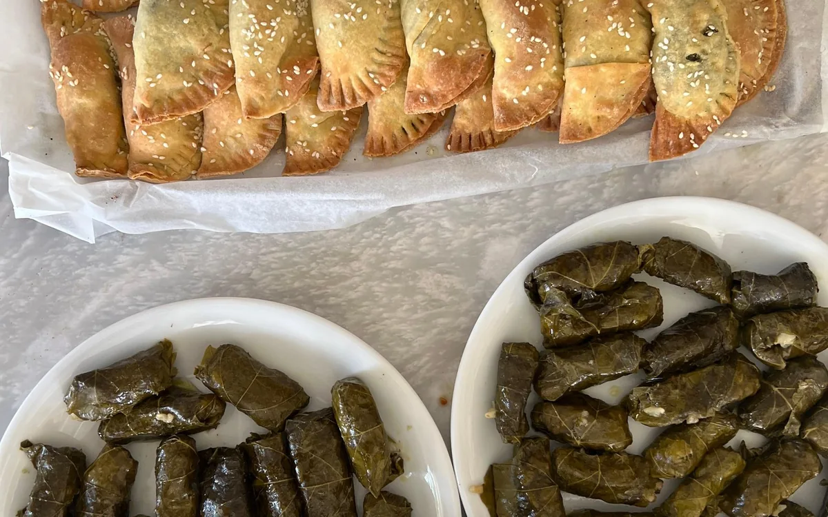 Sesame-topped pastries and two plates of stuffed vine leaves, from the full meal class listing