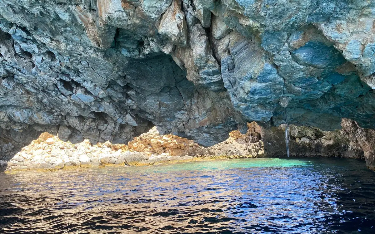 Looking out from inside a sea cave at bright turquoise water
