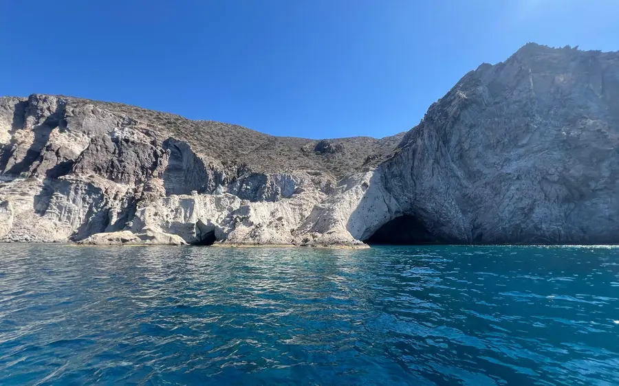 White cliffs with a sea cave above deep blue water